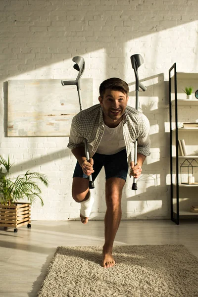 Smiling Man Broken Leg Holding Crutches Home — Stockfoto