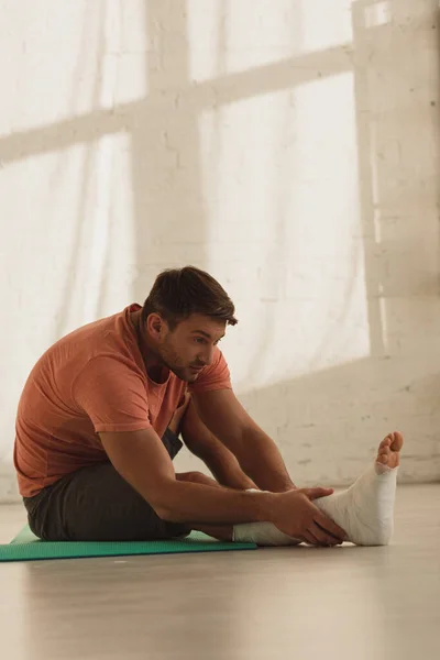 Vue Latérale Homme Avec Jambe Cassée Étirant Sur Tapis Fitness — Photo