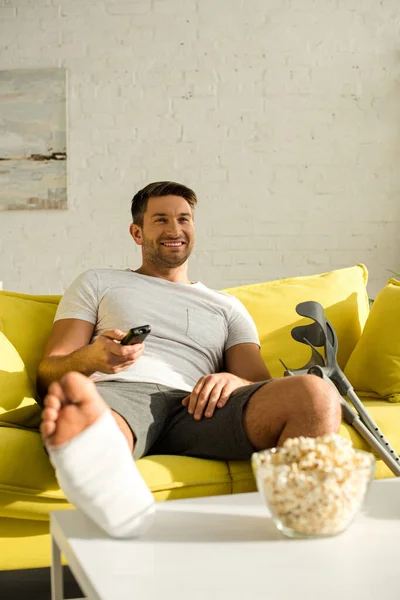 Selective Focus Smiling Man Leg Plaster Bandage Watching Popcorn Coffee — Stockfoto