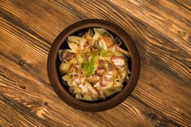 top view of delicious varenyky with cracklings in bowl on wooden table