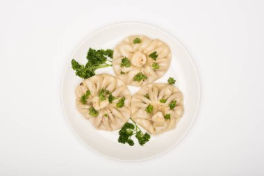 top view of delicious Khinkali with cilantro on plate on white background