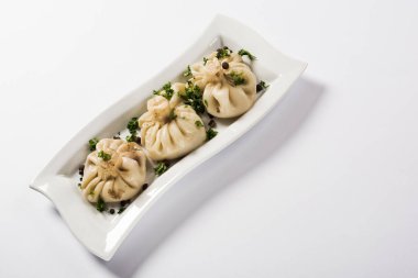 delicious Khinkali with cilantro on plate on white background