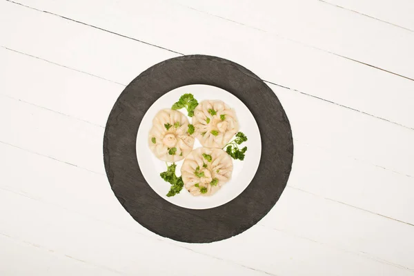 Bovenaanzicht Van Heerlijke Khinkali Met Koriander Bord Witte Houten Tafel — Stockfoto