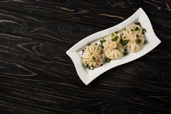 Top View Delicious Khinkali Cilantro Plate Black Wooden Table — Stok fotoğraf