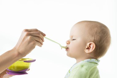 Side view of mother feeding baby with baby nutrition isolated on white