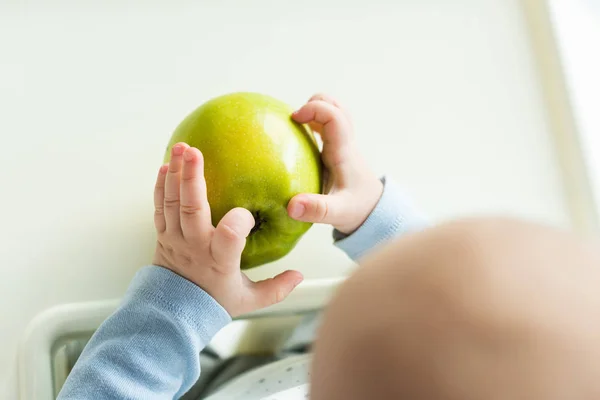 Overhead View Baby Holding Green Apple While Sitting Feeding Chair — ストック写真