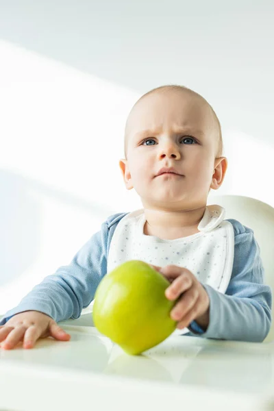 Selektivní Zaměření Zamyšlený Chlapeček Drží Zelené Jablko Zatímco Sedí Krmení — Stock fotografie