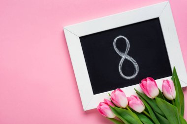 Üzerinde 8 numara ve pembe yüzey üzerinde laleler olan karatahtanın üst görünümü