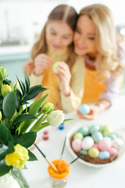 Fuoco Selettivo Tulipani Vicino Madre Figlia Che Dipingono Uova Pasquali — Foto Stock