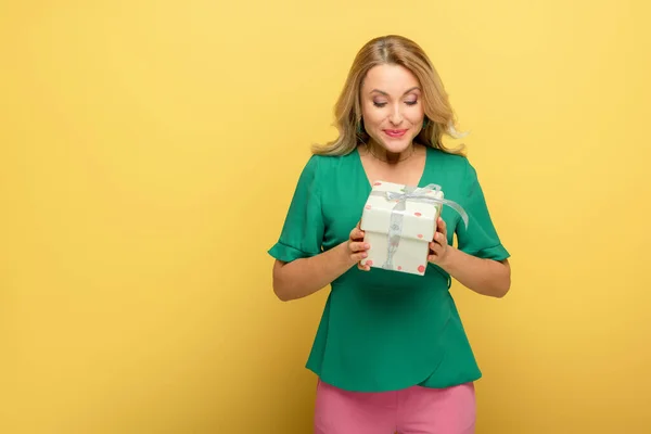 Cheerful Woman Holding Gift Box Isolated Yellow — ストック写真