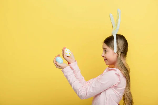 Zijaanzicht Van Schattig Kind Met Konijnenoren Met Geschilderde Paaseieren Geïsoleerd — Stockfoto