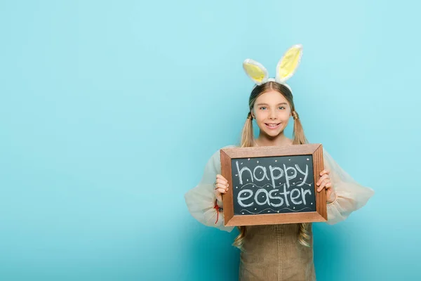 Vidám Gyerek Nyuszifül Tartó Tábla Boldog Húsvéti Felirattal Kék — Stock Fotó