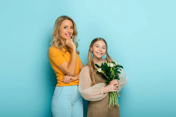 Joyeuse Mère Souriant Près Fille Avec Des Tulipes Sur Bleu — Photo