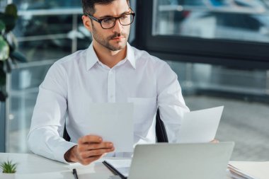 Belgeler ve bilgisayarla çalışan yakışıklı profesyonel çevirmen 