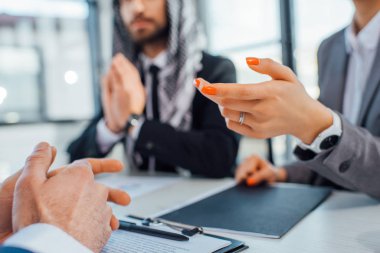 İş ortakları, çevirmenle ofisinde yapılan görüşmede sözleşmeyi tartışıyor