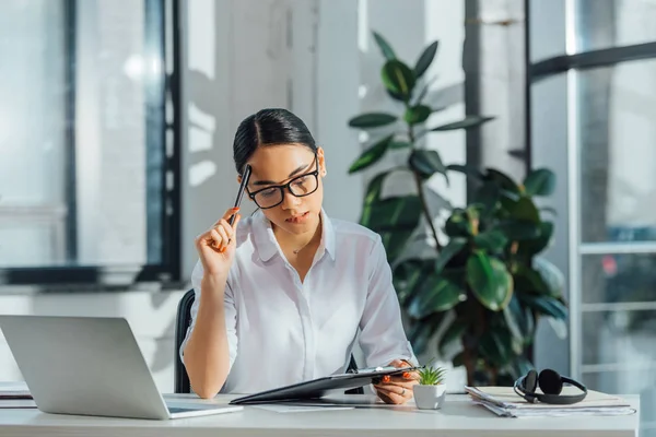 Pensive Asian Translator Working Laptop Documents Modern Office — Stock Photo, Image