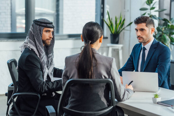 multiethnic business partners on meeting with translator in office