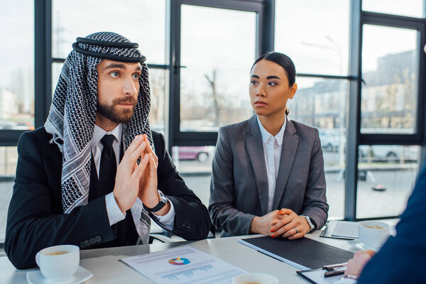 arabic business partners discussing contract on meeting with translator in office