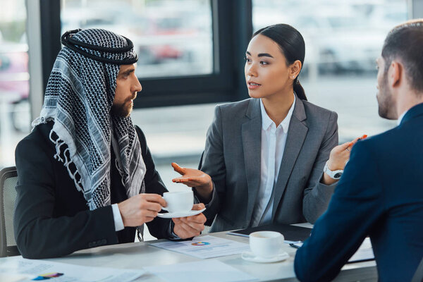 multiethnic business partners on meeting with translator in office