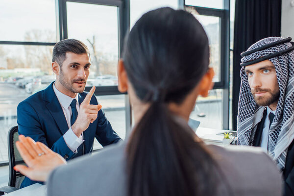 professional multicultural business partners discussing contract on meeting in office