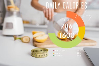 Selective focus of measuring tape and scales near fit girl cutting fresh fruits for smoothie on kitchen table, daily calories illustration clipart