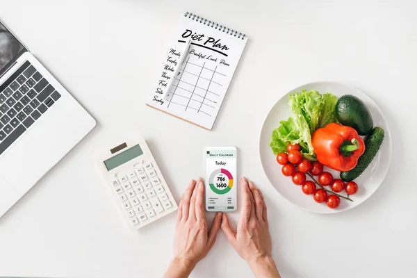 Top View Woman Holding Smartphone Calculator Notebook Vegetables White Background — Stok fotoğraf