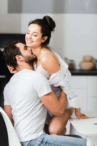 Όμορφος Άντρας Φιλάει Χαμογελαστή Γυναίκα Σουτιέν Και Πουκάμισο Στην Κουζίνα — Φωτογραφία Αρχείου