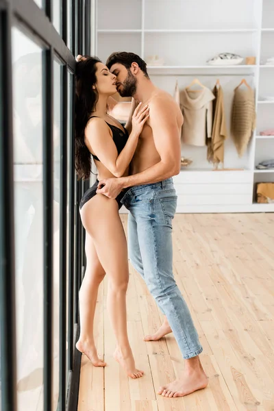 Vista Lateral Homem Bonito Beijando Mulher Atraente Lingerie Perto Janela — Fotografia de Stock
