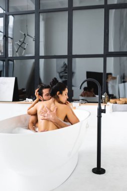 Güzel çıplak kadın birlikte banyo yaparken yakışıklı erkek arkadaşına dokunuyor. 