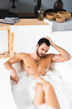 Kaslı adam evde kız arkadaşıyla banyo yaparken gözlerini kaçırıyor.