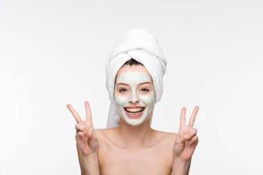 Yüzünde maske ve kafasında havluyla gülümseyen kız zafer işaretlerini bembeyaz gösteriyor.