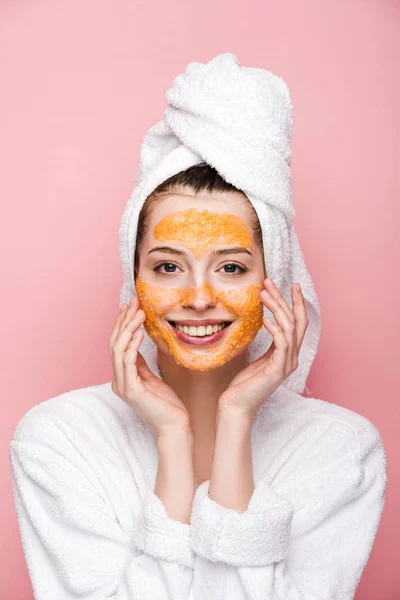 快乐的女孩 戴着柑橘面膜 看着用粉色隔离的相机 触摸着她的脸 — 图库照片