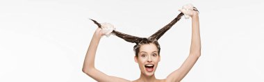 Heyecanlı bir kızın uzun saçlarını yıkarken eğlendiği panoramik bir çekim. 