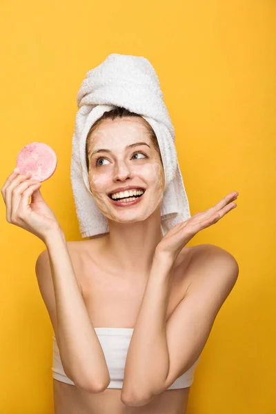 Happy Girl Moisturizing Facial Mask Looking Cosmetic Sponge Isolated Yellow — Stock Photo, Image