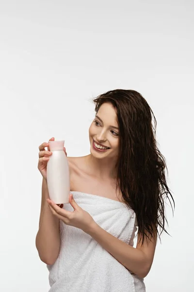Усміхнена Дівчина Дивиться Геть Тримаючи Пляшку Шампуню Ізольовано Білому — стокове фото