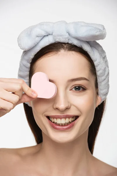 Happy Girl Covering Eye Heart Shaped Cosmetic Sponge While Looking — Stock Photo, Image