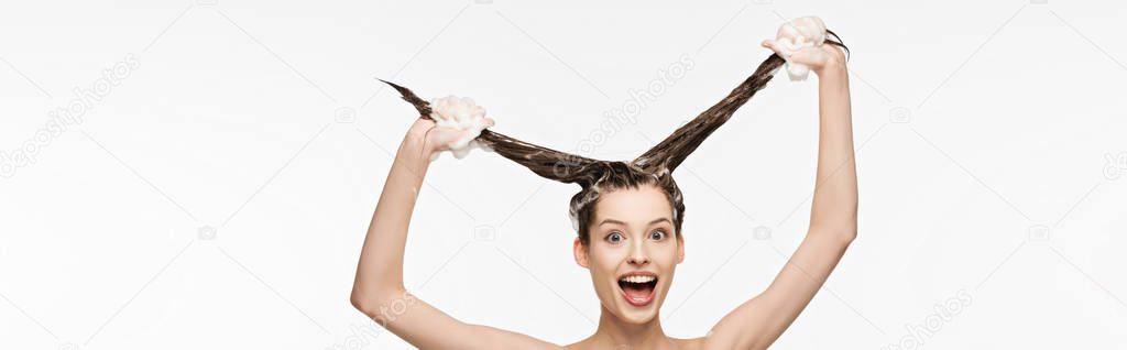panoramic shot of excited girl having fun while washing long hair isolated on white 