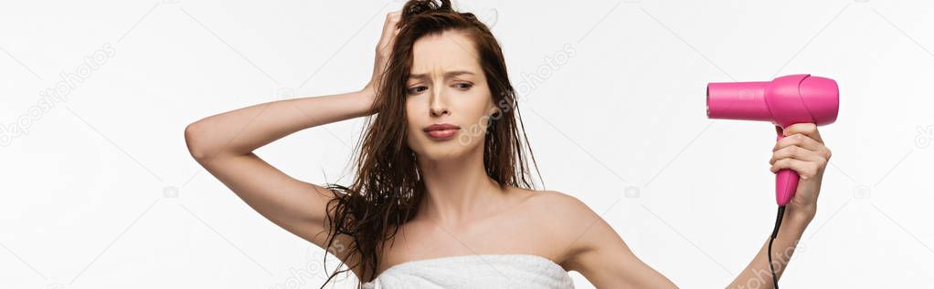 panoramic shot of displeased girl drying hair with hair dryer isolated on white