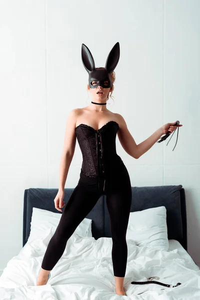 Sexy Woman Bunny Mask Holding Flogging Whip While Standing Bed — Stock Photo, Image