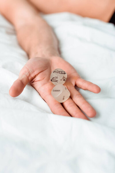 обрезанный вид человека с кубиками камасутры в руке
