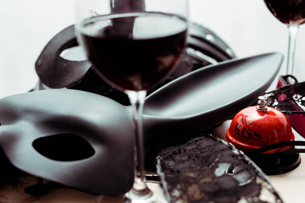 селективный фокус маски кролика рядом с колокольчиком поцелуя и очки с красным вином
 