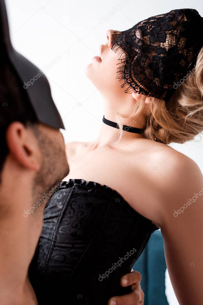 selective focus of man looking at blindfolded woman 