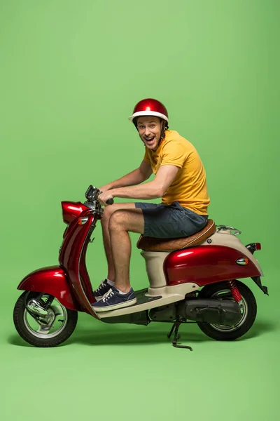 Seitenansicht Des Zustellers Gelber Uniform Auf Motorroller Isoliert Auf Grün — Stockfoto