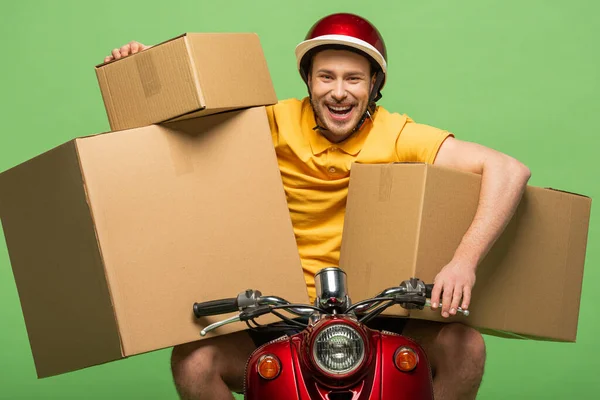 开开心心的送货员 身穿黄色制服 骑滑板车 盒子与绿色隔离 — 图库照片