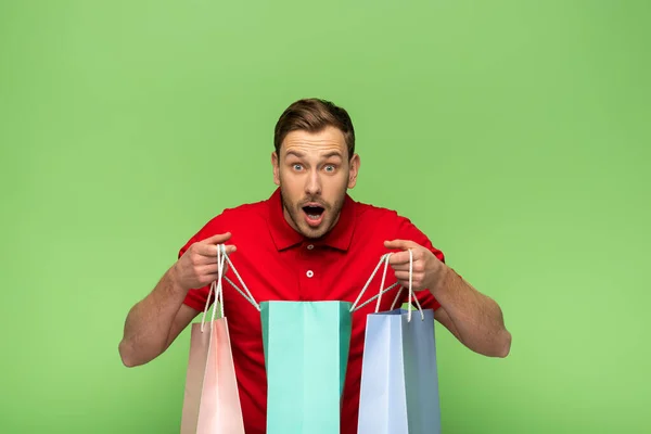 Chocado Jovem Segurando Sacos Compras Isolados Verde — Fotografia de Stock