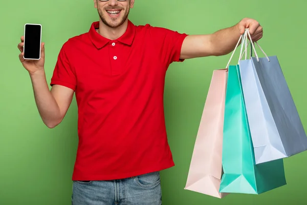 Oříznutý Pohled Šťastného Muže Držícího Nákupní Tašky Smartphone Zelené — Stock fotografie
