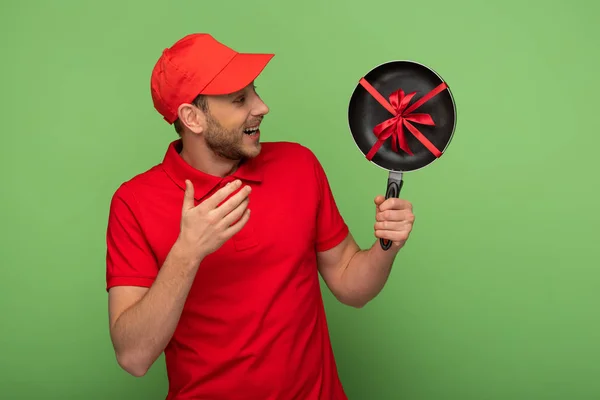 Homem Entrega Feliz Vermelho Uniforme Segurando Frigideira Com Arco Verde — Fotografia de Stock