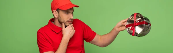 Pensive Delivery Man Red Uniform Holding Pan Bow Isolated Green — Stock Photo, Image