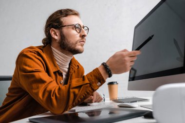 Ofisteki masadaki bilgisayar monitöründe Stylus 'u gösteren 3D sanatçının seçici odağı 