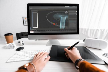 Masada 3D tasarım projesi üzerinde çalışırken grafik tableti ve bilgisayar klavyesi kullanan dijital tasarımcının kırpılmış görünümü 